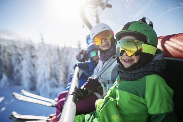 A family sits on a ski lift