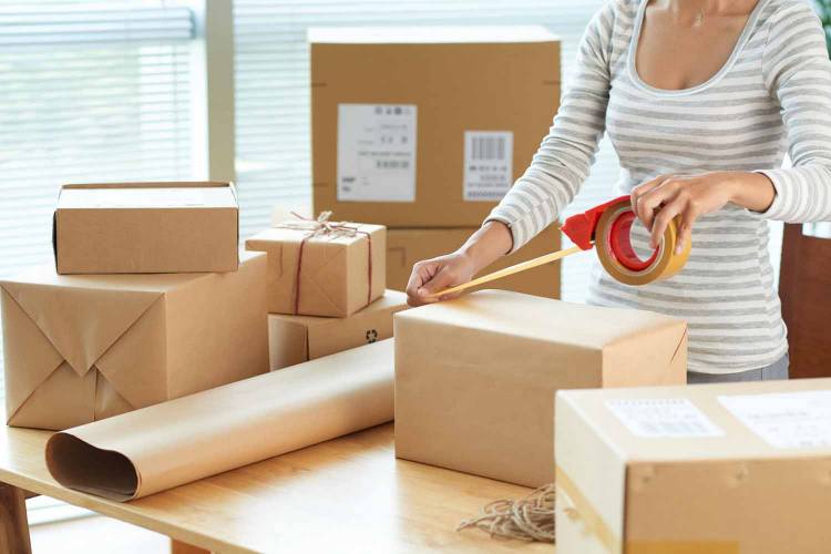 Woman packing up shipping boxes